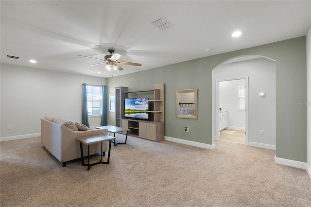 carpeted living room with ceiling fan