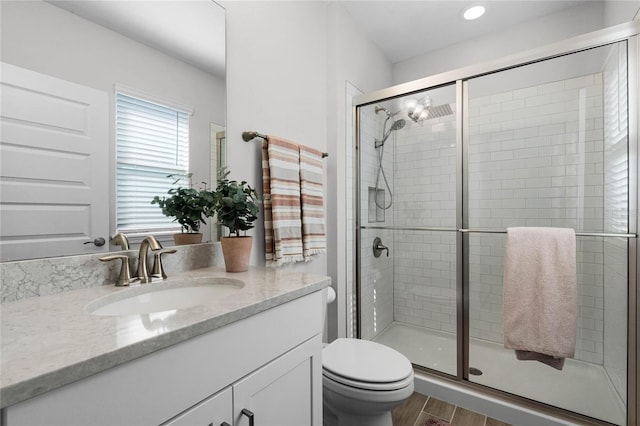 bathroom with vanity, an enclosed shower, hardwood / wood-style floors, and toilet