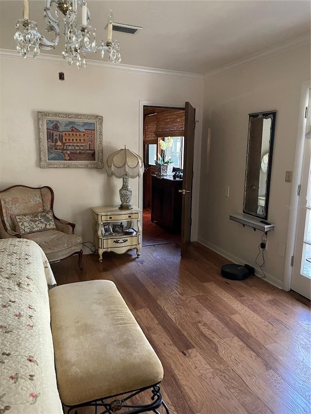 living room with hardwood / wood-style floors, ornamental molding, and a notable chandelier