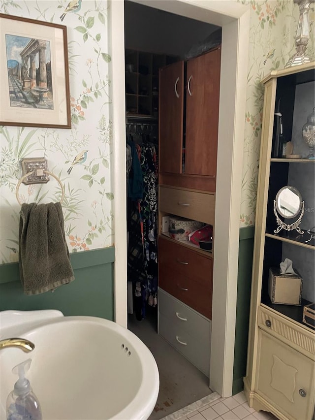 bathroom with tile patterned flooring, a tub, and sink