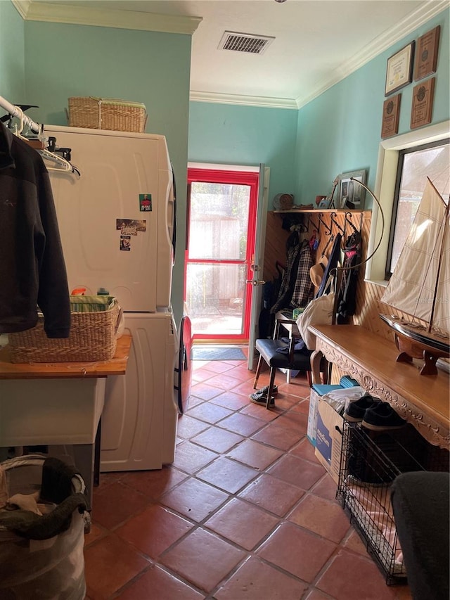 interior space featuring crown molding, stacked washer and clothes dryer, and tile patterned floors