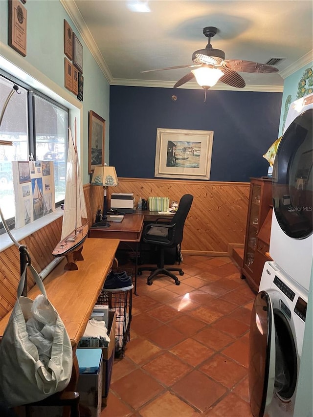 tiled office with ceiling fan, stacked washer and clothes dryer, ornamental molding, and wooden walls