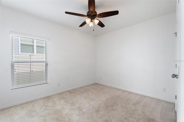 spare room with ceiling fan and light colored carpet