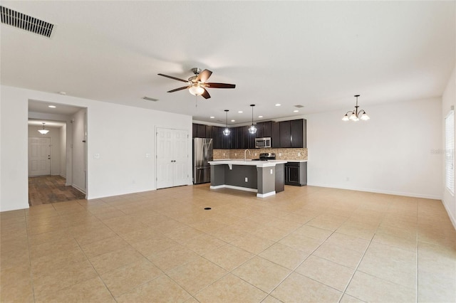 unfurnished living room with ceiling fan with notable chandelier, light tile patterned floors, and sink