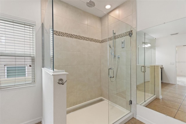 bathroom with a shower with shower door and tile patterned floors