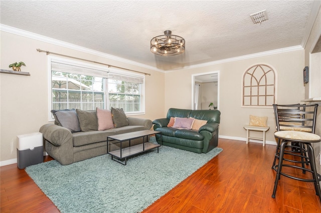 living room with dark wood-type flooring, ornamental molding, and a textured ceiling