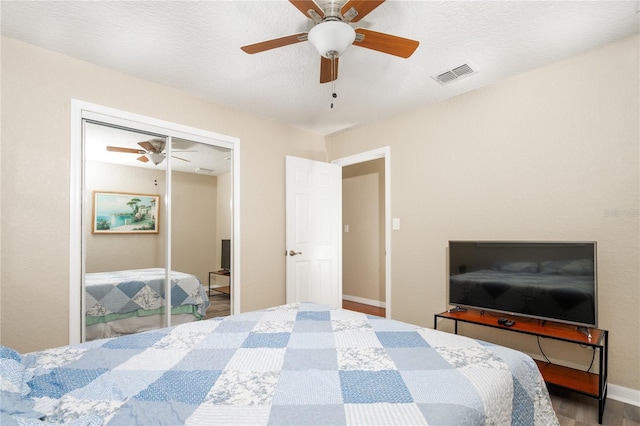 bedroom featuring wood-type flooring, a textured ceiling, ceiling fan, and a closet