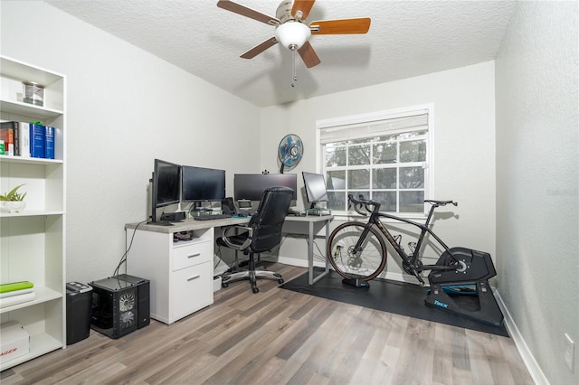 office space featuring ceiling fan, hardwood / wood-style flooring, built in features, and a textured ceiling