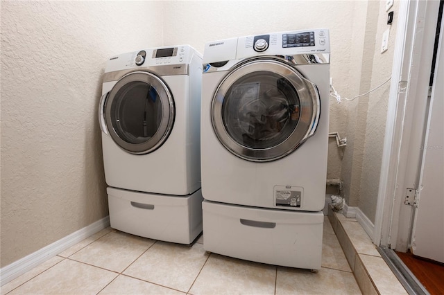 laundry room featuring separate washer and dryer and light tile patterned floors