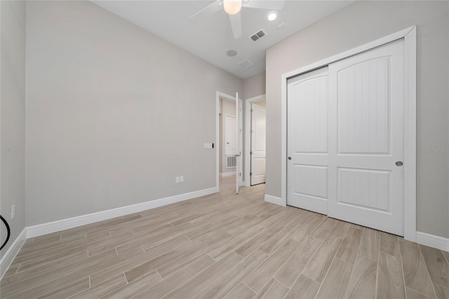 unfurnished bedroom with a closet, light wood-type flooring, visible vents, and baseboards