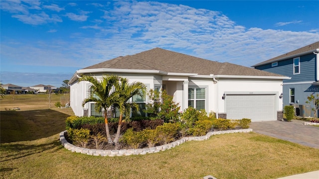 ranch-style house featuring driveway, a garage, roof with shingles, a front lawn, and stucco siding