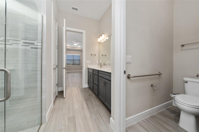 full bath with toilet, wood finished floors, vanity, visible vents, and baseboards