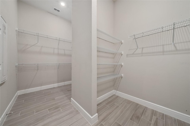 spacious closet featuring wood finish floors and visible vents