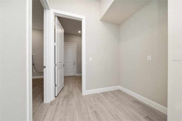 corridor featuring wood finish floors and baseboards