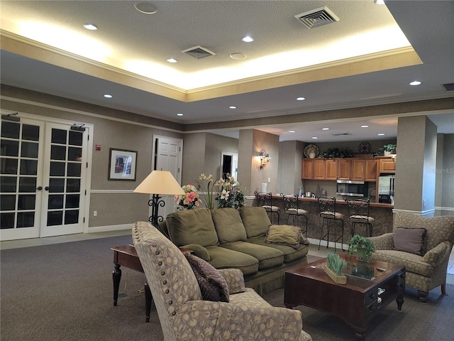 12216 Wild Iris Way Unit 112, Orlando, FL 32837 - carpeted living room with ornamental molding, visible vents, and a raised ceiling