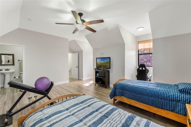 bedroom featuring vaulted ceiling, connected bathroom, sink, ceiling fan, and light hardwood / wood-style floors