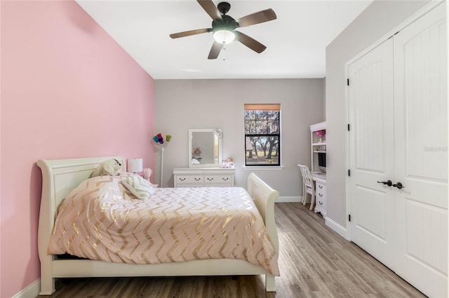 bedroom with ceiling fan, a closet, and light hardwood / wood-style flooring