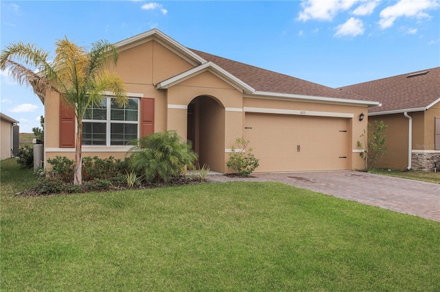 ranch-style home with a garage and a front lawn