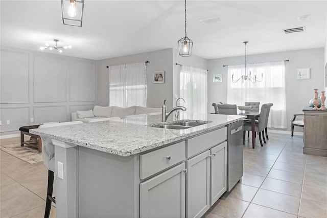 kitchen with pendant lighting, sink, an inviting chandelier, a center island with sink, and stainless steel dishwasher