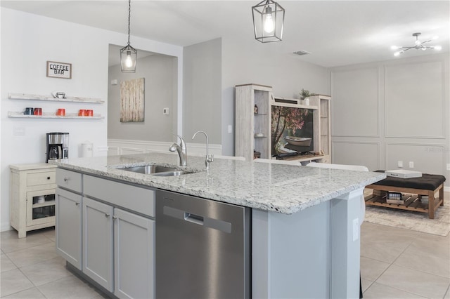 kitchen with pendant lighting, dishwasher, an island with sink, sink, and light tile patterned floors