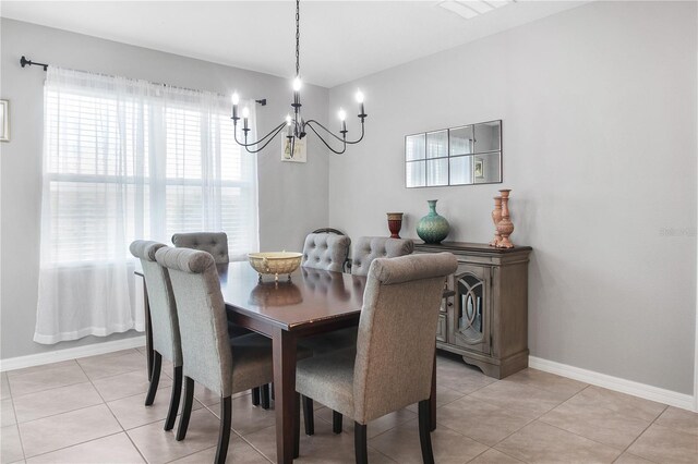 tiled dining room with a chandelier