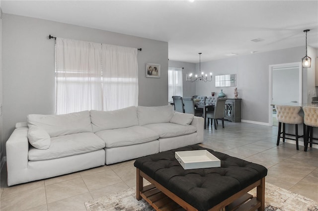 tiled living room featuring a notable chandelier