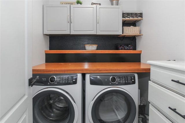 washroom with cabinets and washer and dryer