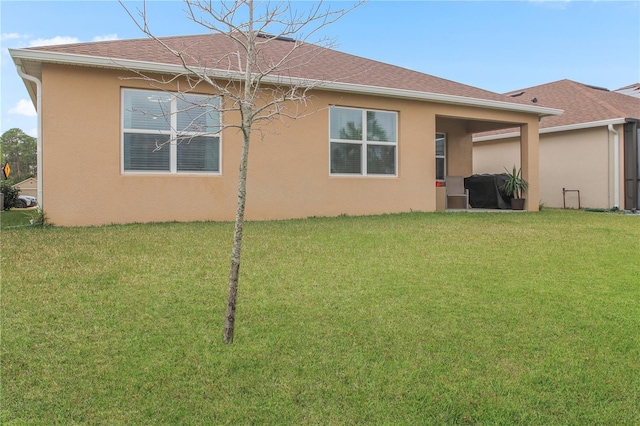 rear view of house featuring a lawn