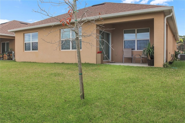 rear view of house with a patio area and a lawn