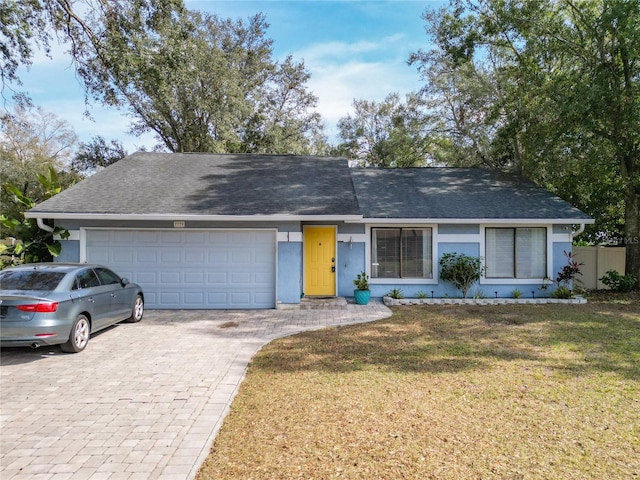 ranch-style house featuring a garage and a front yard