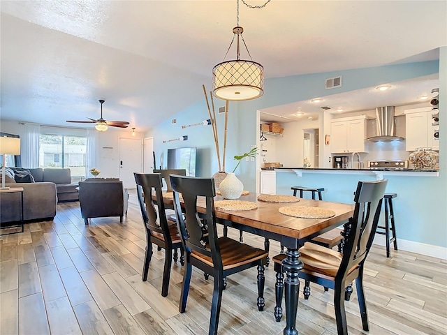 dining room with ceiling fan and vaulted ceiling