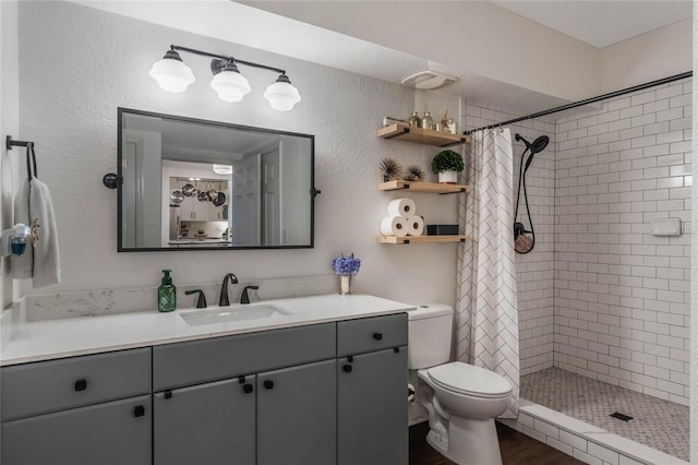 bathroom featuring toilet, vanity, a shower with curtain, and hardwood / wood-style flooring