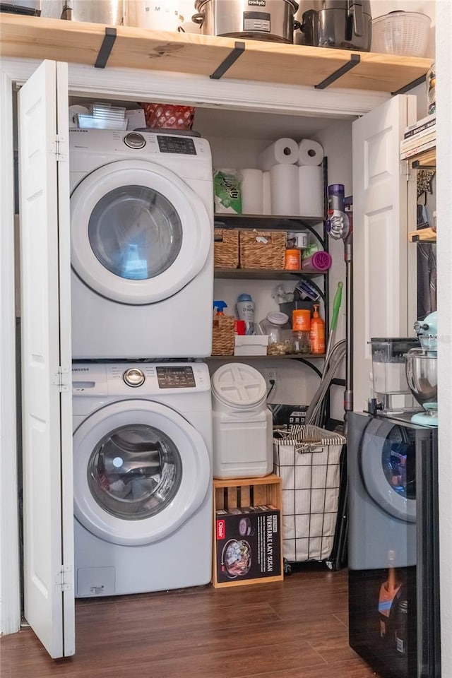 clothes washing area with dark hardwood / wood-style floors and stacked washer and clothes dryer