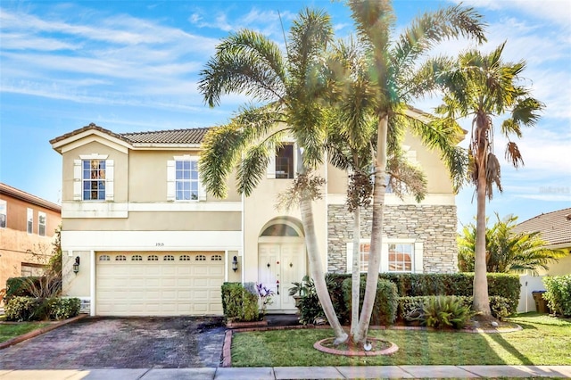 mediterranean / spanish-style home featuring a front lawn and a garage