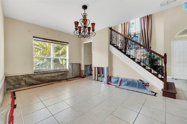 unfurnished living room with tile patterned floors and a notable chandelier