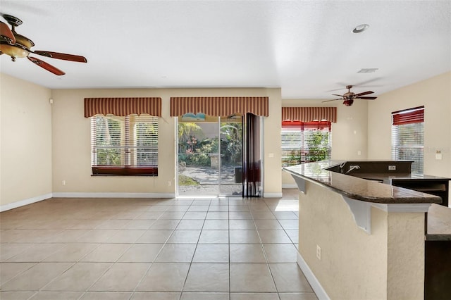 kitchen featuring light tile patterned floors and dark stone counters