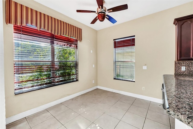 tiled empty room featuring ceiling fan