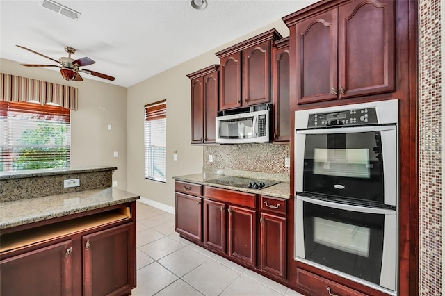 kitchen featuring appliances with stainless steel finishes, ceiling fan, backsplash, light tile patterned flooring, and light stone counters