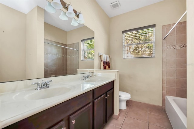 full bathroom with toilet, vanity, tile patterned flooring, and tiled shower / bath