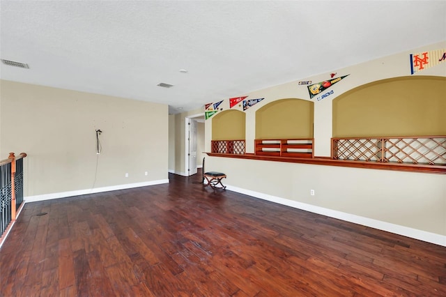 unfurnished room featuring a textured ceiling and hardwood / wood-style flooring