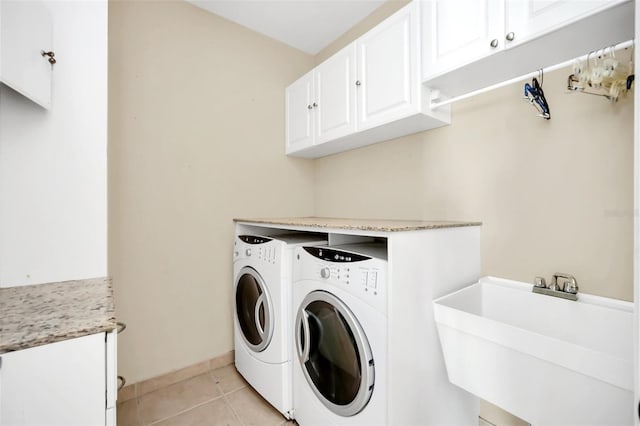 laundry area featuring cabinets, light tile patterned floors, sink, and independent washer and dryer