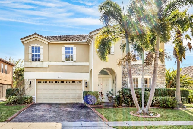 mediterranean / spanish-style house with a garage and a front yard