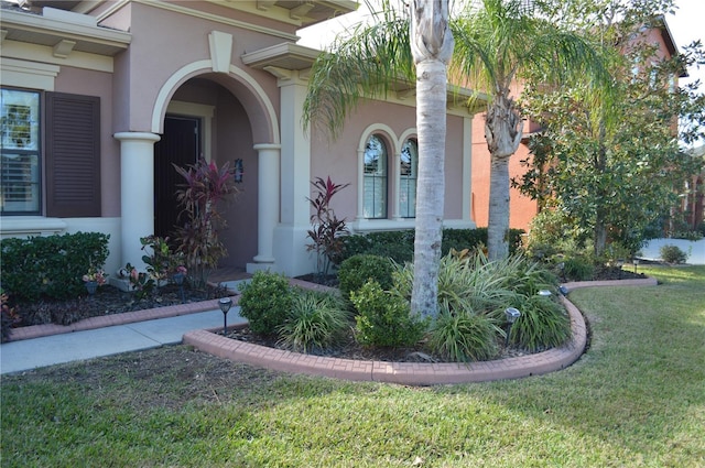 view of exterior entry with a lawn