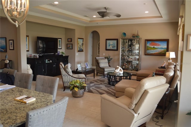 living room featuring a raised ceiling, crown molding, and ceiling fan with notable chandelier