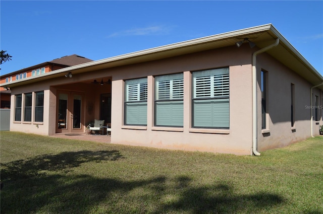 back of house with a patio area and a yard