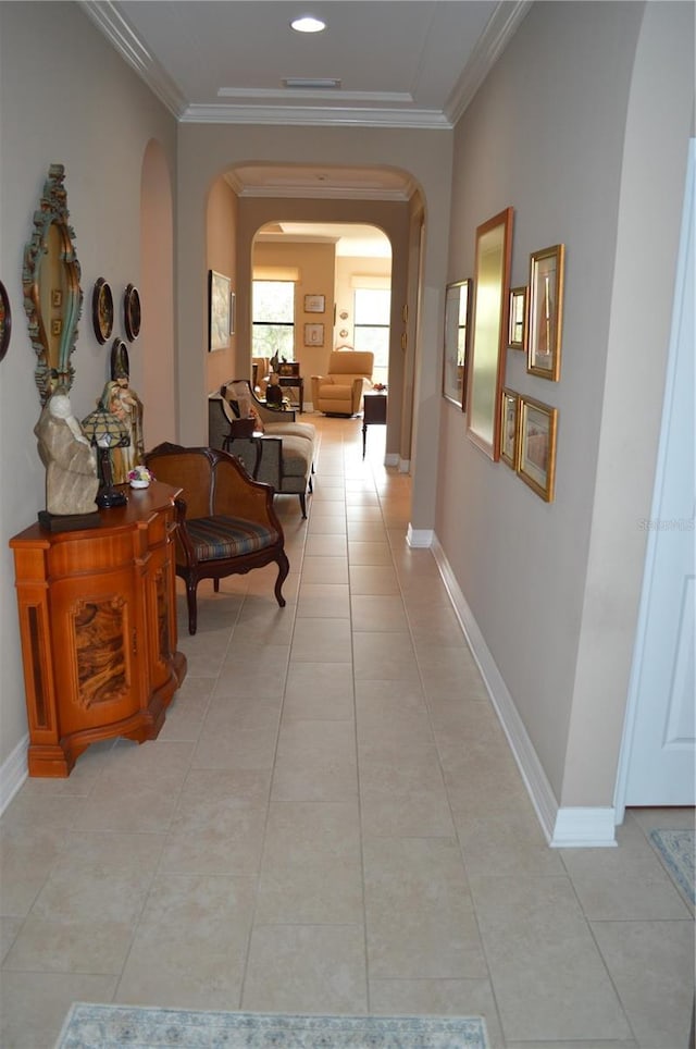 hallway featuring light tile patterned floors and crown molding