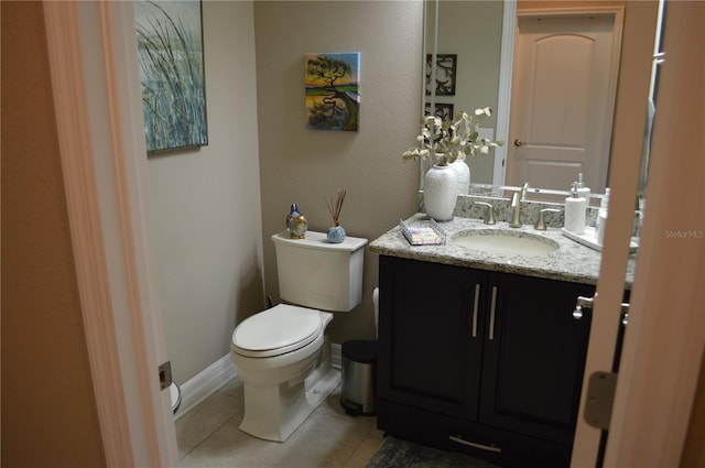 bathroom featuring toilet, vanity, and tile patterned flooring