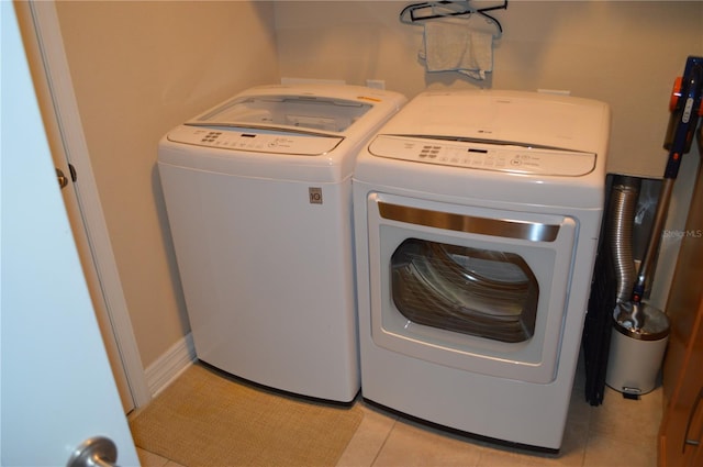 laundry room with separate washer and dryer and light tile patterned floors