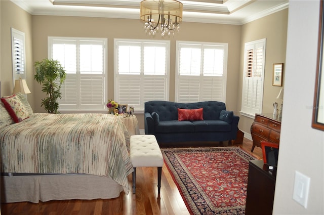 bedroom with multiple windows, a chandelier, and hardwood / wood-style flooring