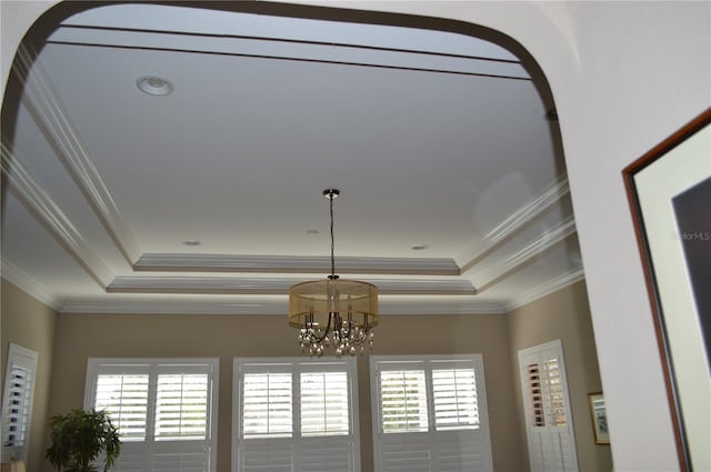 room details featuring an inviting chandelier, crown molding, and a tray ceiling